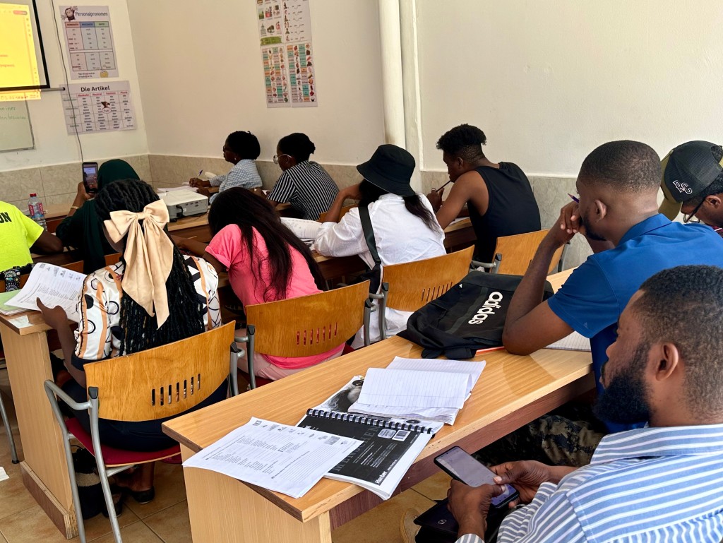 Cours d'allemand avec apprenants et support visuel en salle.