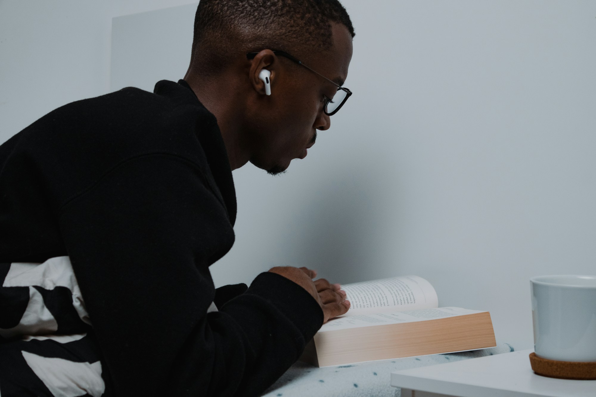 Adulte concentre en lecture a table, preparation personnelle aux cours.